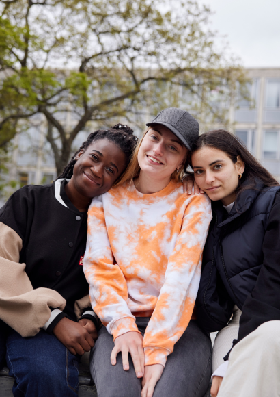 Respekt: Drei Freundinnen sitzen nebeneinander und lehnen sich aneinander an