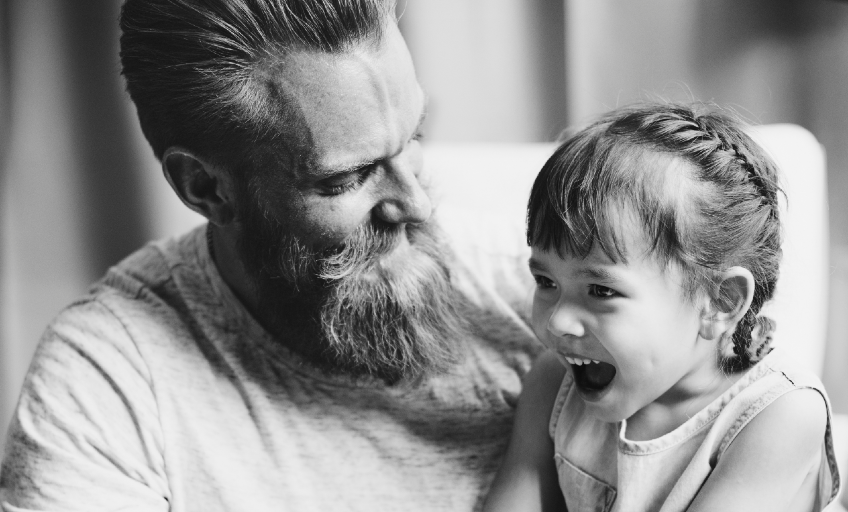 Morgen-Rituale mit dem Kind: Ein bärtiger Vater hält seine Tochter im Arm.