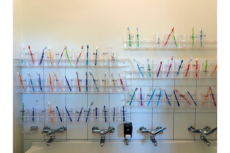 Après le déjeuner à l'école, une armée de brosses à dents attend d'être utilisée.