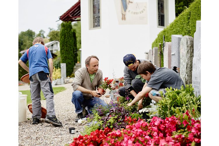 Erich Gisi with his boys at the cemetery. The family looks after the grave together.