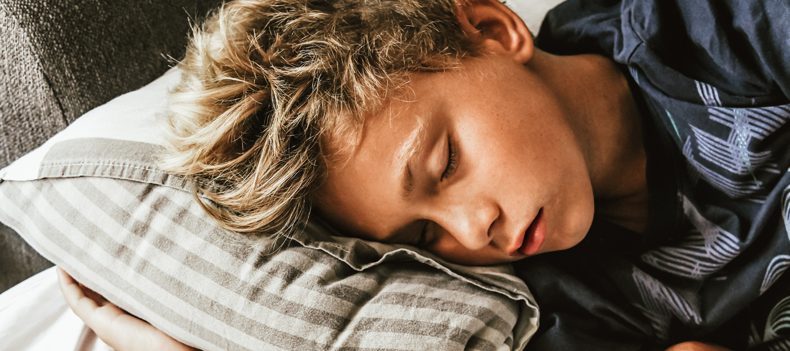 Schlafstörungen bei Teenagern. Jugendlicher liegt auf einem Kissen und schläft.