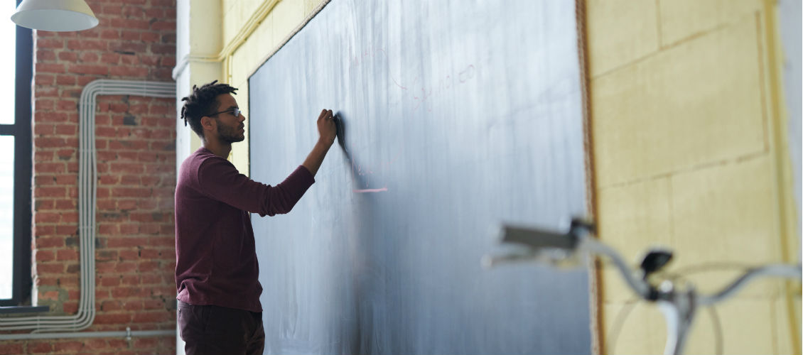 Kommunikation mit der Schule: Lehrer schreibt an Wandtafel