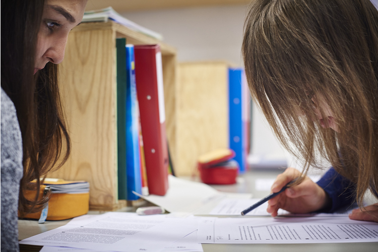 2 / 3 Heilpädagogik-Praktikantin Maryam Ahmadi hilft Sophie. Sie erinnert die Schülerin daran, den Text Zeile für Zeile zu lesen. 