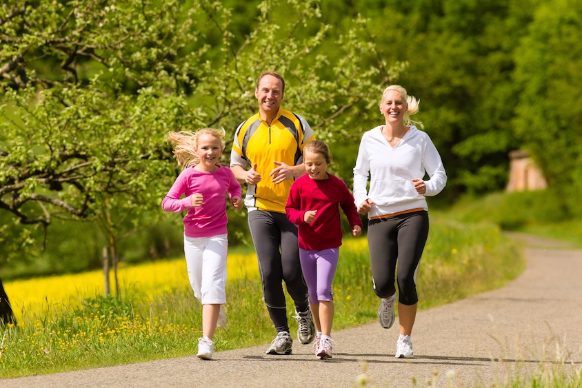 Family running in the meadow for sport Damit die Kilos purzeln
