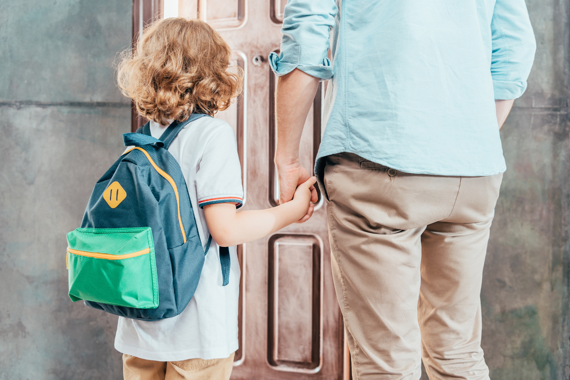 rear view of dad and son going to school «Ich leb bei Mami – und bei Papi»