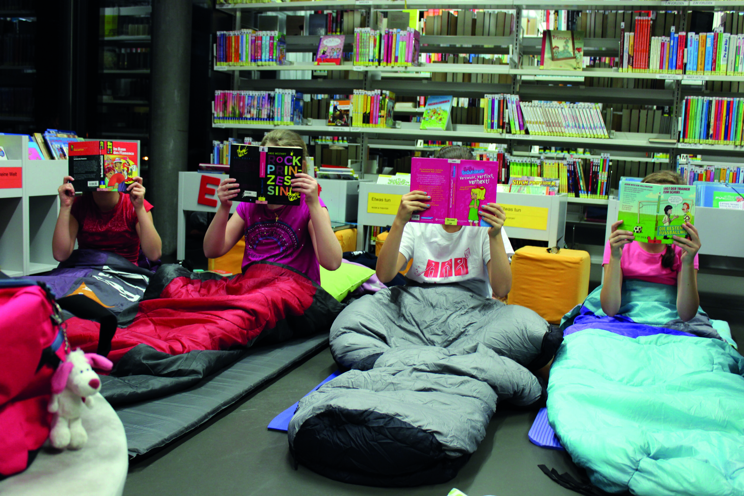 Kinder-bei-Lesenacht-im-Schlafsack-hinter-Bu_chern Wo sich kleine und grosse Bücherwürmer treffen