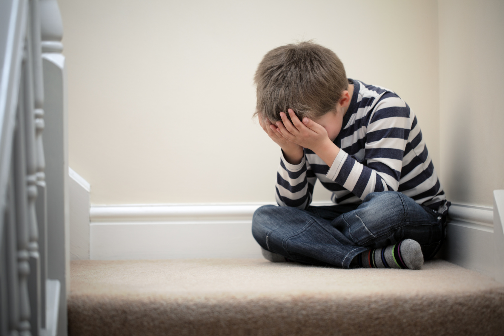 Upset problem child sitting on staircase Was tun