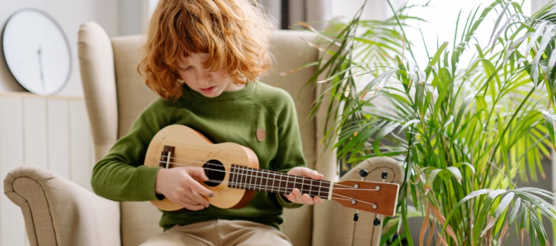 Instrument üben: Kind spielt Harmonika mit Notenblatt