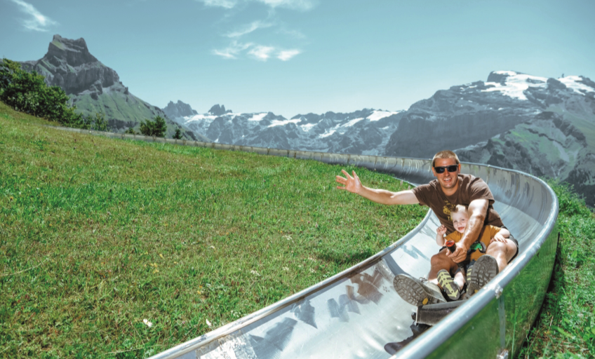 Sommerrodelbahn_Vater mit Kind_Hahnen und Titlis im Hintergrund_848x512