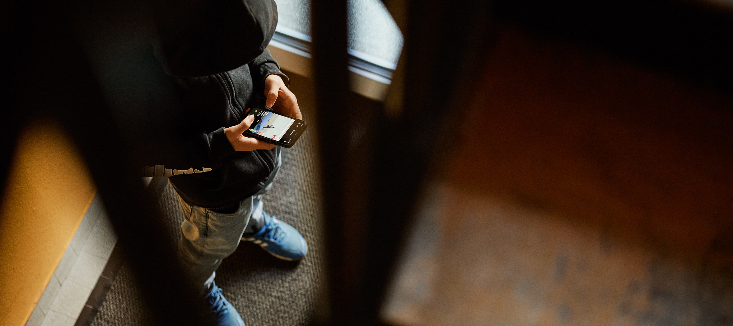 Schulfrust: Junge steht im Treppenhaus mit Handy