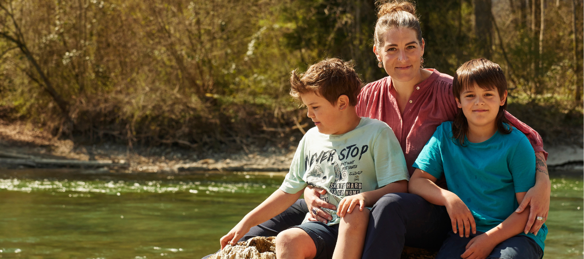 Bedürfnisorientierte Erziehung: Eine Mutter mit ihren beiden Söhnen am Fluss